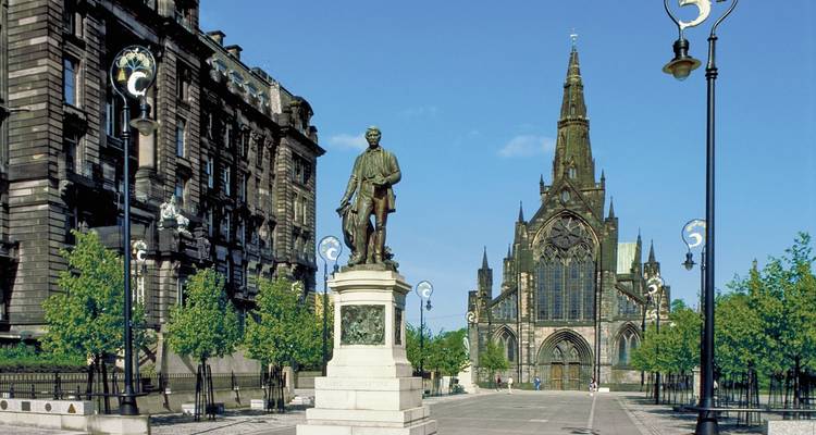 Plaza histórica de la ciudad con una estatua y catedral.