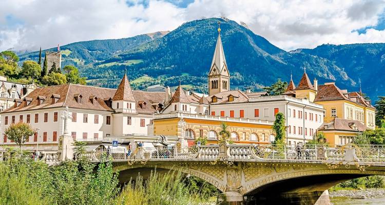 A picturesque town with a church and a bridge over a river.