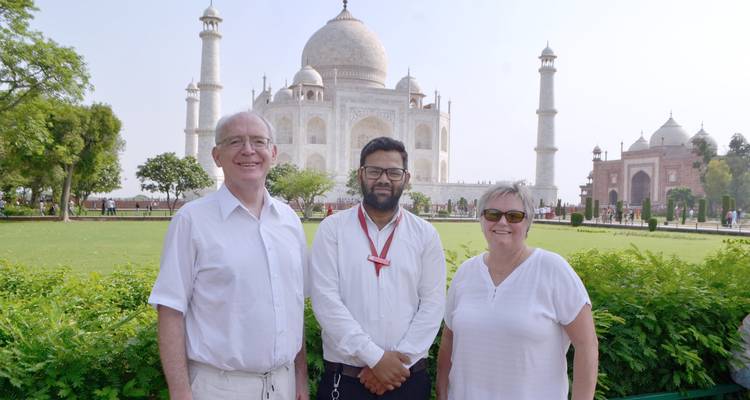 Trois personnes debout devant le Taj Mahal par une journée ensoleillée.
