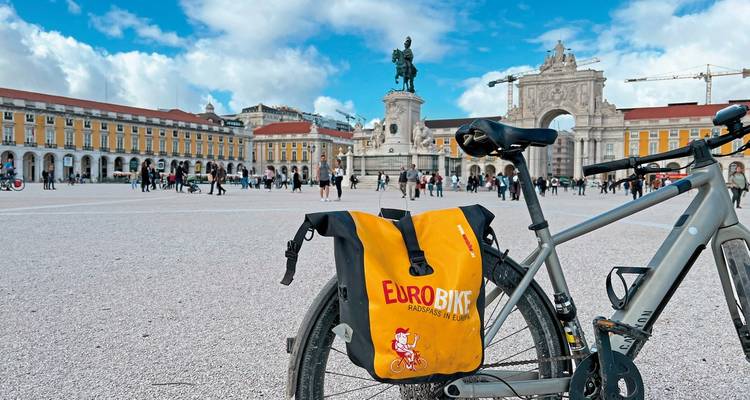 Eurobike-markiertes Fahrrad auf einem belebten Platz mit einem Denkmal.