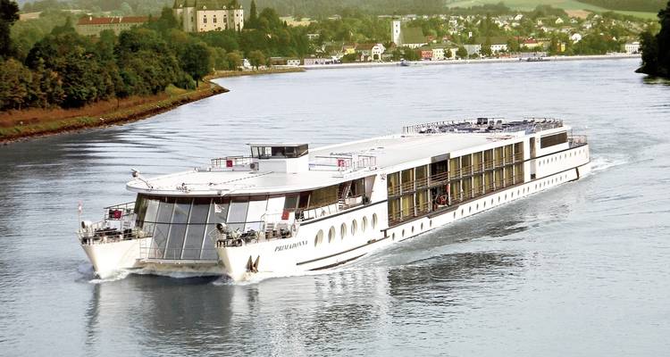 Flusskreuzfahrtschiff, das auf einem Fluss mit Städten entlang seiner Ufer fährt.