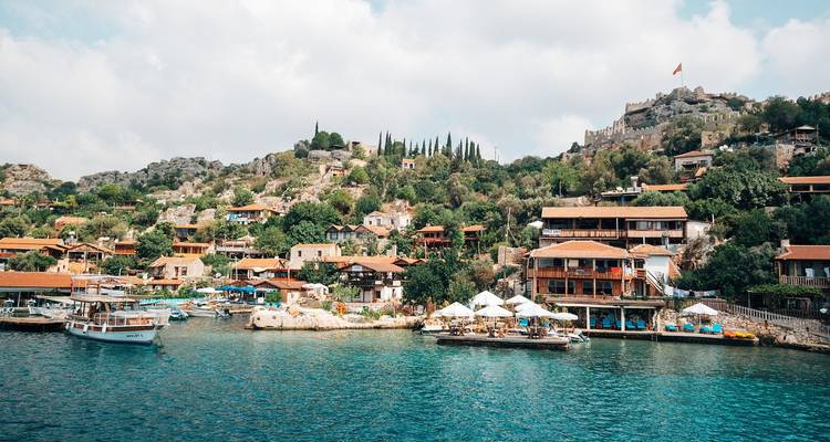 Kleurrijke kustplaats met helderblauwe wateren en boten.