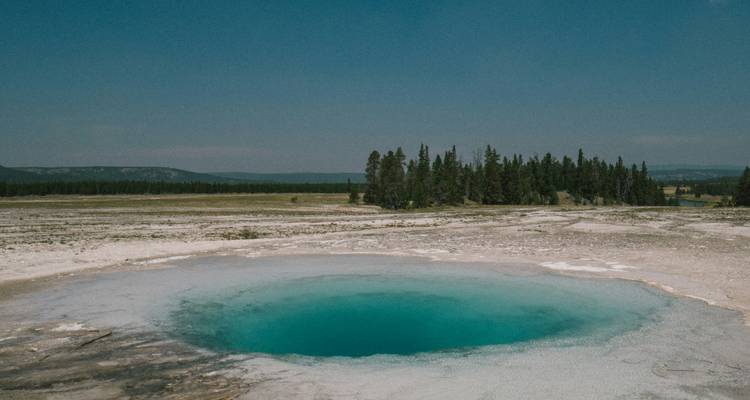 Petit bassin de source chaude avec paysage plat.