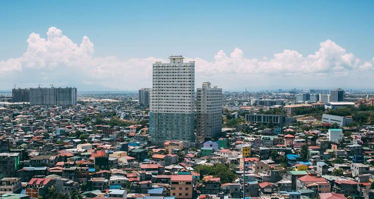 Extenso horizonte urbano con edificios de gran altura sobre casas abarrotadas y coloridas