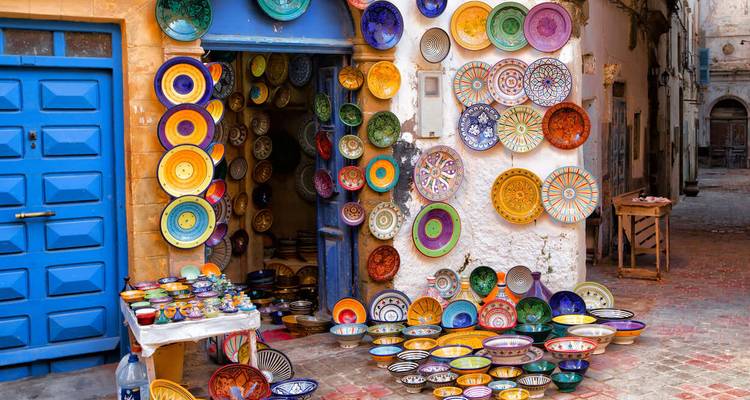 Shop with colorful ceramic plates on a rustic street.