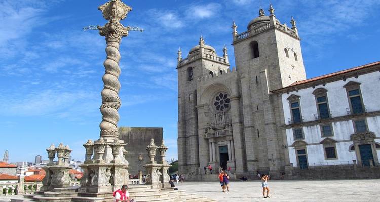 Historische Kathedrale mit verzierter Säule und Menschen rundherum.