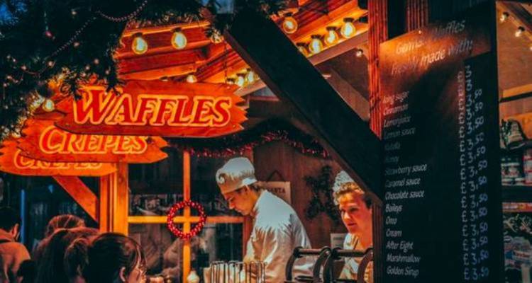 Een wafel- en pannenkoekenkraam met een rustieke houten inrichting.