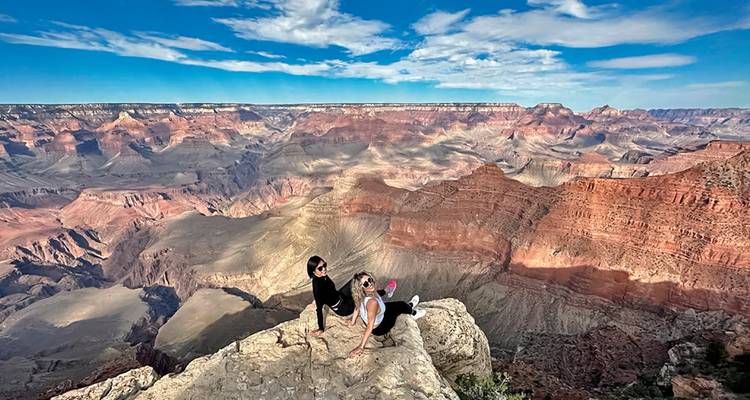 Zwei Personen posieren am Rand des Grand Canyon mit weiten Ausblicken.