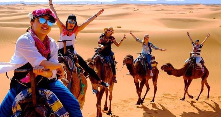 Group of people riding camels in the desert