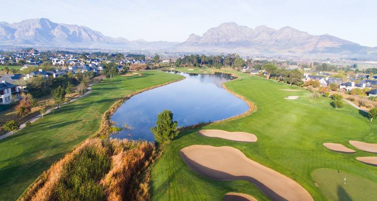 Luchtfoto van een golfbaan met bergen.