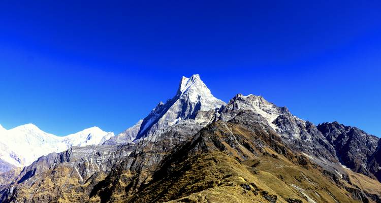 Picos montañosos nevados contra un cielo azul despejado.