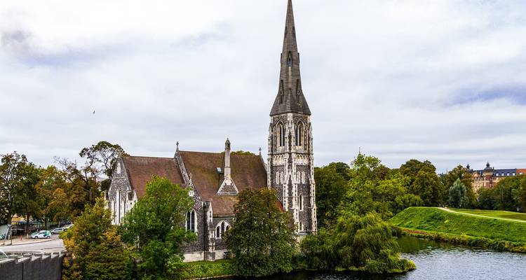 St Alban's Church staat naast een bladrijke gracht omgeven door groen in Kopenhagen.
