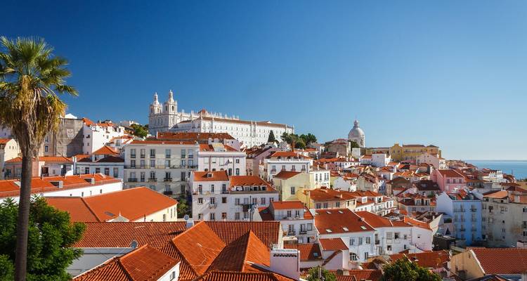 Vista panorámica de las azoteas del casco antiguo colorido con iglesias y mar bajo un cielo azul vivido