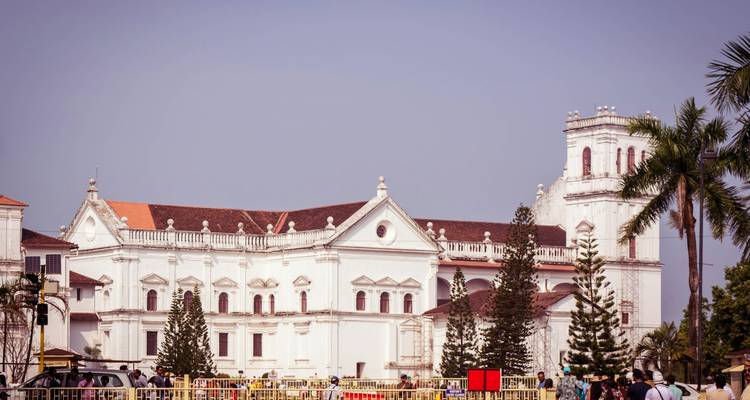A historic white building with a crowd of people.