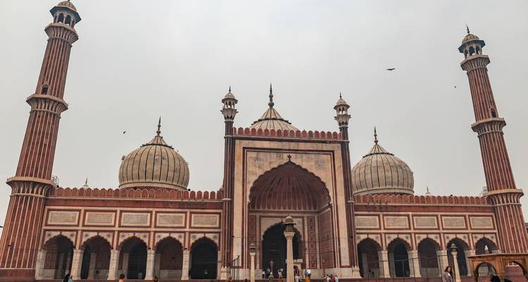 Jama Masjid mit umgebenden Besuchern und einem bewölkten Himmel.