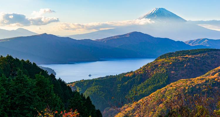 Bergige Landschaft mit einem See und dem Mount Fuji im Hintergrund.
