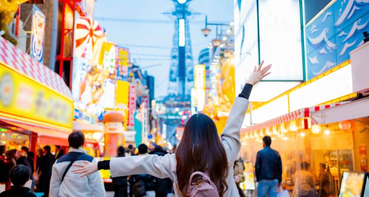 Überfüllte Straße mit hellen Lichtern und Menschen, die die Sehenswürdigkeiten genießen.