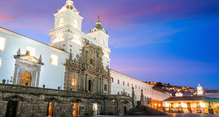 Catedral blanca con fachada elaborada bajo un cielo de atardecer.