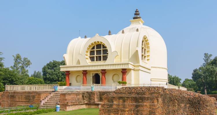 Weiße Chorten-ähnliche Struktur zwischen Ruinen.