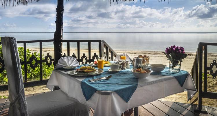 Mesa de desayuno puesta con vista a la playa.