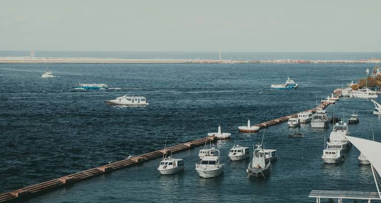 Boote, die in einem Hafen anlegen, mit einem fernen Blick auf den Ozean.