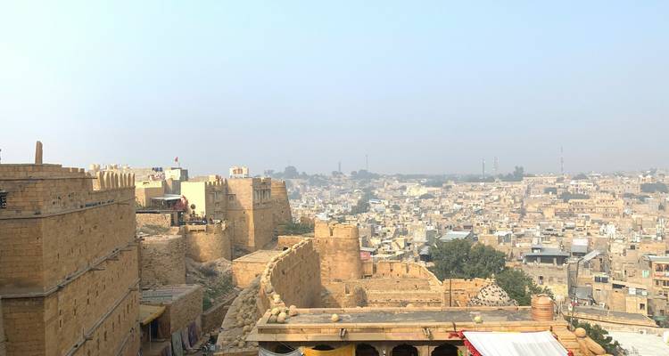 Historic fort with a city view on a hazy day.