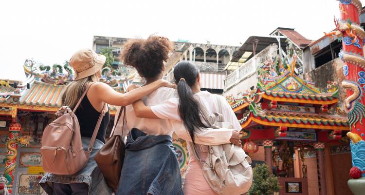 Groep mensen die voor een traditionele tempel staan.