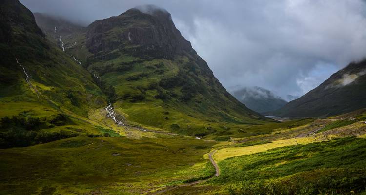 Malerische Landschaftsansicht eines Bergtals mit üppigem Grün.