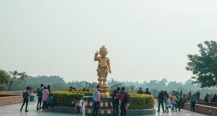 Goldenes Denkmal mit Besuchern in einem Park.