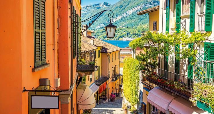 Charmante schmale Gasse mit bunten Gebäuden und Blick auf den See.