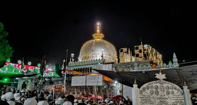 Verlichte religieuze plek bruisend van bezoekers 's nachts.