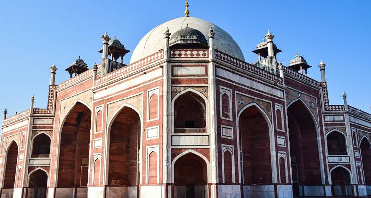 Koepelvormig, sierlijk gebouw met ingewikkelde patronen tegen een heldere blauwe lucht.