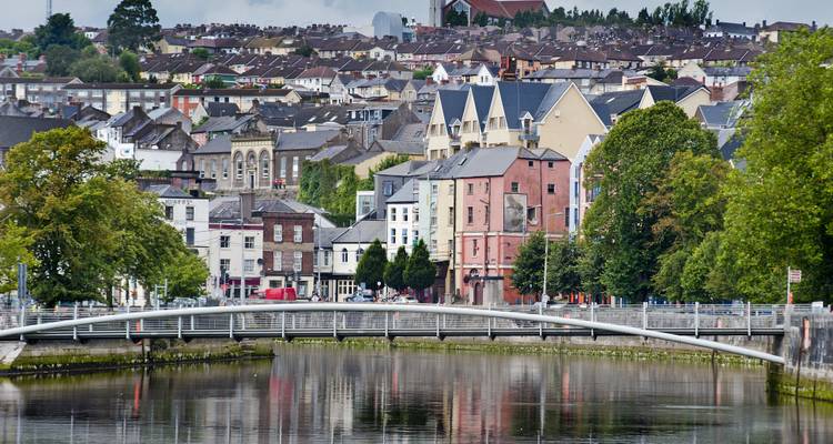 Stadtlandschaft von Cork mit historischer Brücke über einem Fluss.