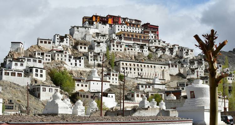 Un complexe monastique construit sur une colline avec des stupas blancs.