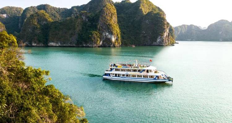 Boot varend op de turquoise wateren van Halong Bay.