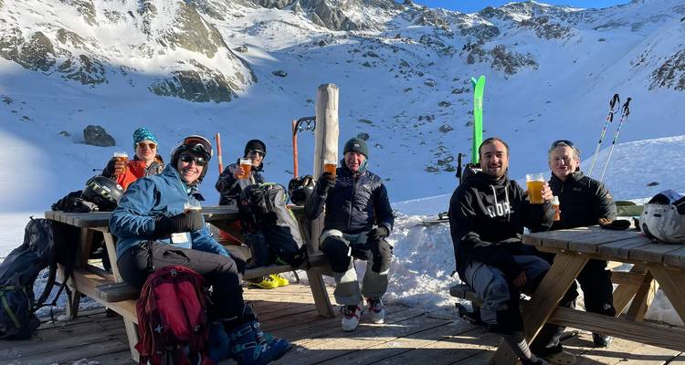 Un groupe de personnes profitant de boissons avec vue sur une montagne enneigée.