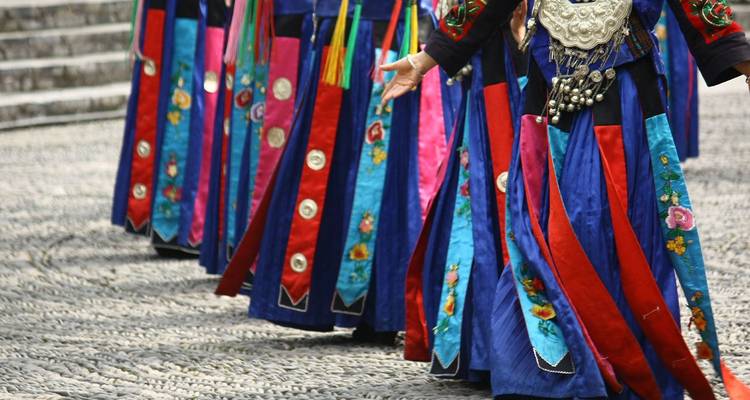 Primer plano de faldas bordadas tradicionales y coloridas que usan los bailarines durante una presentación cultural.