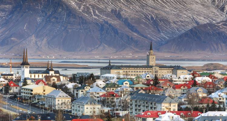 Los tejadillos coloridos de Reikiavik se extienden bajo un telón de fondo de montañas nevadas y ensenadas costeras.