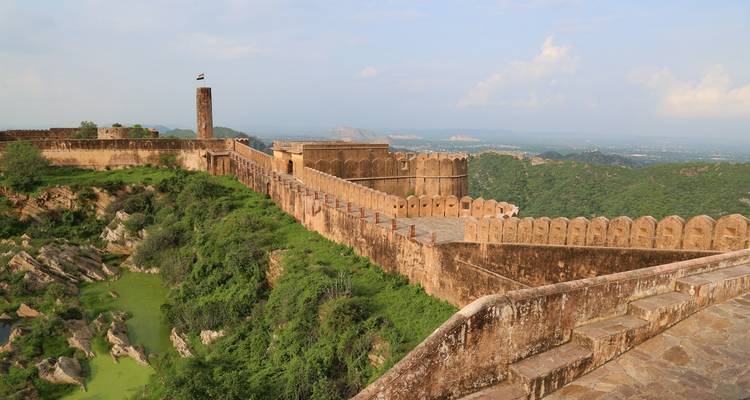 Festungsmauern mit Blick auf ein Tal mit üppigem Grün.