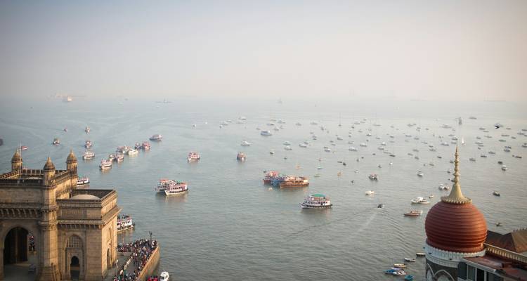 Luftaufnahme eines Hafens mit dem Gateway of India und zahlreichen Booten.
