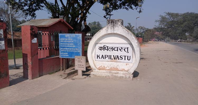 Ein Schild mit Text in Englisch und einer anderen Sprache am Straßenrand.