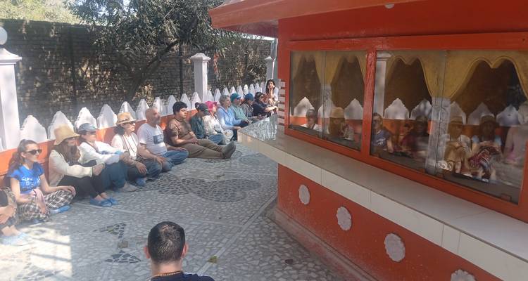 Eine Gruppe von Menschen, die auf dem Boden in der Nähe eines Schreins sitzen.