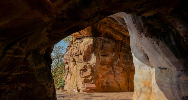Grotingang met oude stenen bank erbinnen.