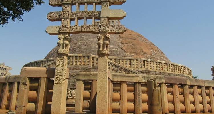 Stupa met ingewikkelde gravures en een omheinde behuizing.