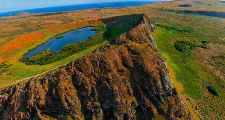 Vista aérea del cráter Rano Kau con una laguna azul y acantilados costeros espectaculares.
