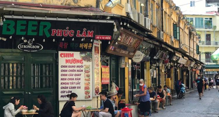 Straßenverkäufer entlang einer lebendigen Straße in Hanoi.