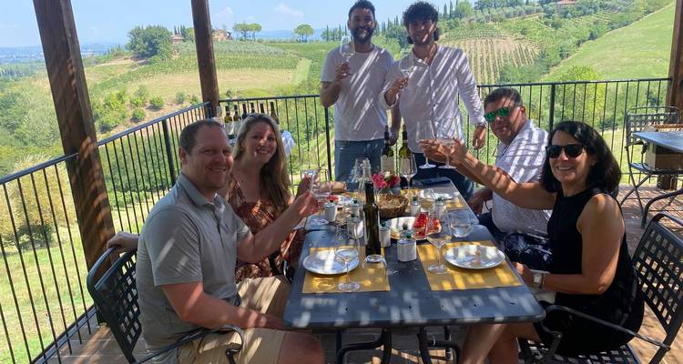 A group of people enjoying a meal with a vineyard view.
