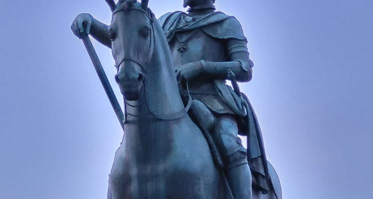A bronze statue of a person on a horse.