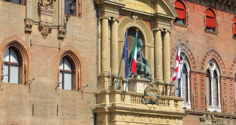 Gebäudefassade mit Flaggen und einer Statue.