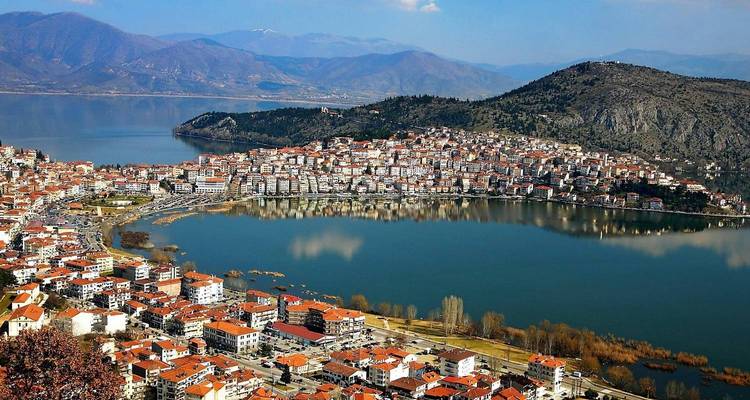 Une vue panoramique d'une ville avec un lac et des collines environnantes.
